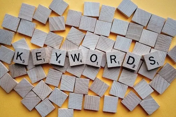 Fichas de madera con letras que forman la palabra keywords sobre un fondo amarillo