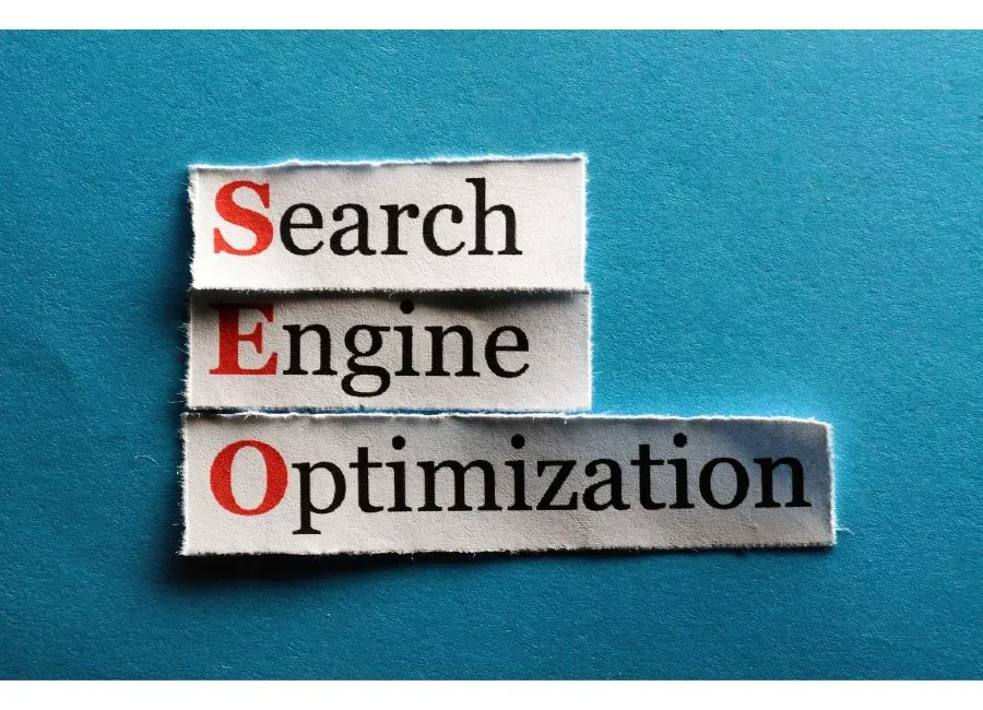 Papeles con las palabras Search Engine Optimization sobre un fondo azul turquesa